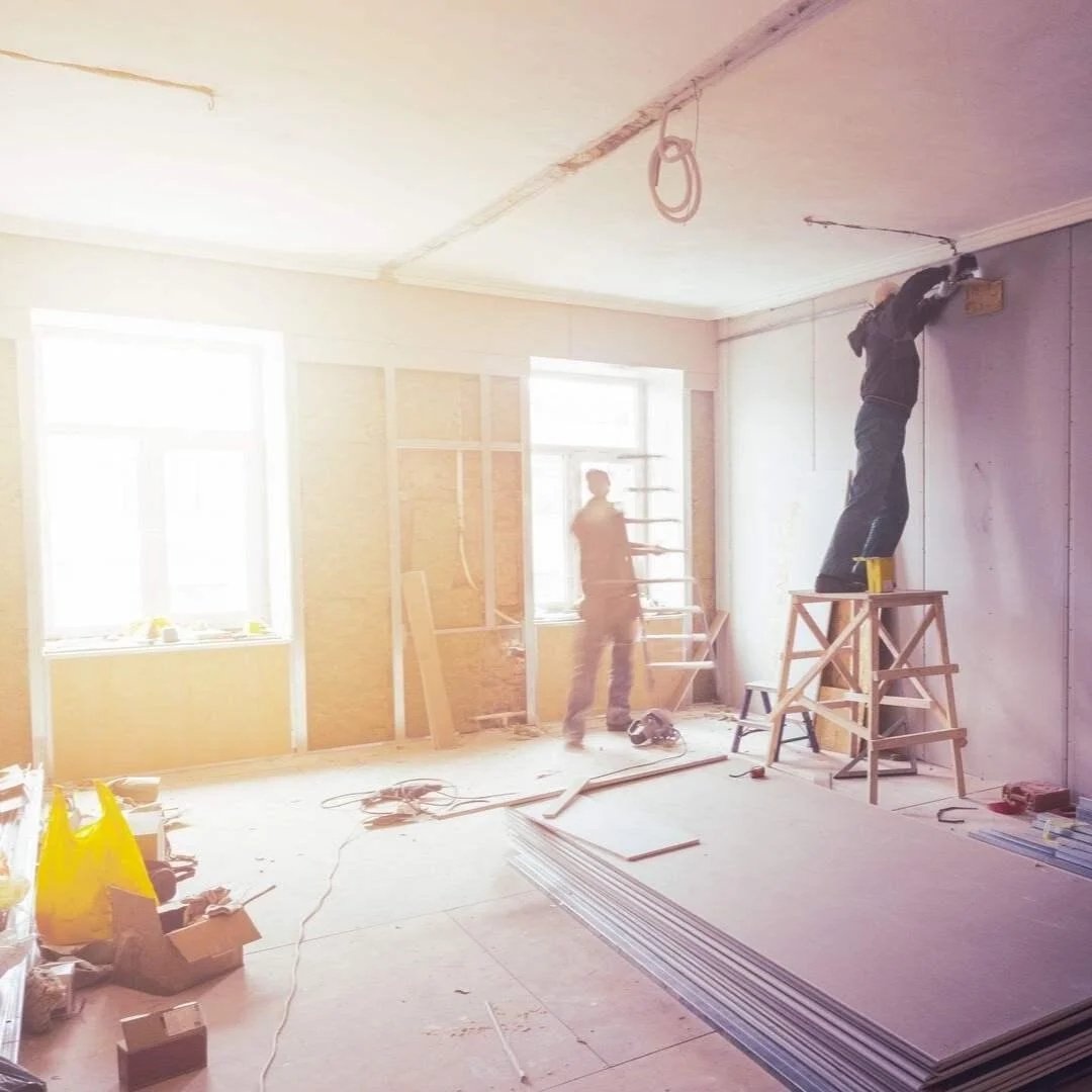 Plasterer working on a wall in a sunlit room