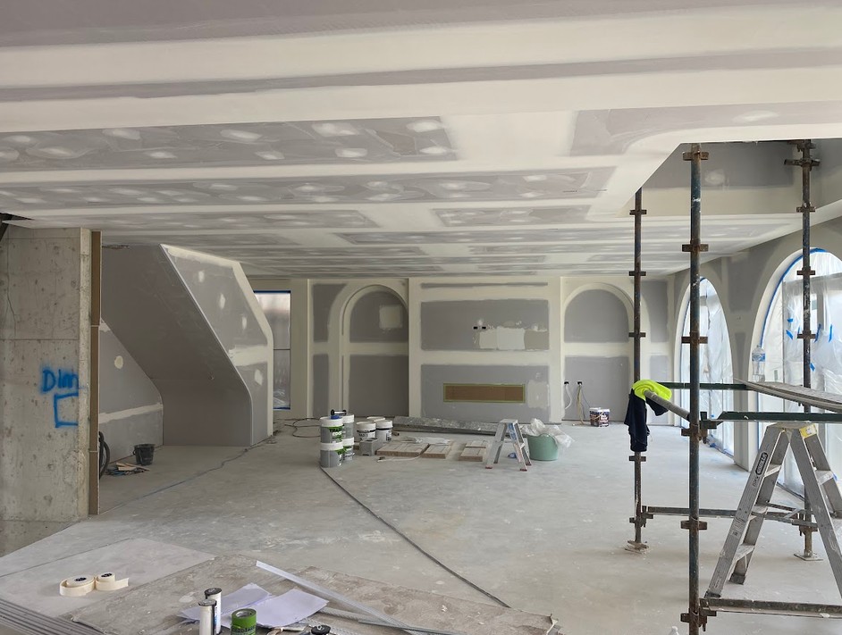 Two plasterers carrying a plasterboard sheet