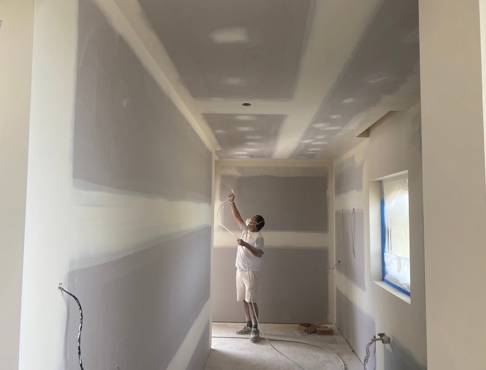 Finished home interior with coffered ceiling and curved staircase