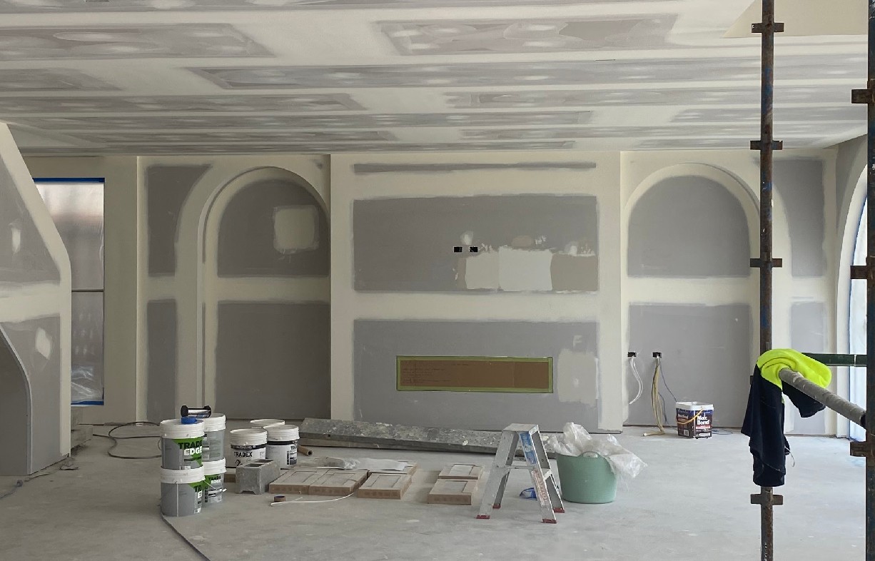 Plasterer finishing a freshly set plasterboard wall in Brisbane